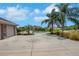 Front yard of a home with palm trees, a long driveway, and a two-car garage in a suburban neighborhood at 508 Bacio St, New Smyrna Beach, FL 32168