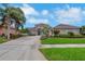 Beautiful single-story home featuring a well-manicured lawn, lush landscaping, and a long driveway leading to the front entrance at 508 Bacio St, New Smyrna Beach, FL 32168