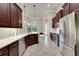 A kitchen featuring modern stainless steel appliances, white countertops, dark cabinets and a view to the pool at 508 Bacio St, New Smyrna Beach, FL 32168