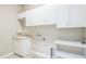 A spacious laundry room with white cabinets, countertop space, sink and tile flooring at 508 Bacio St, New Smyrna Beach, FL 32168