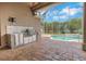 The screened patio features an outdoor kitchen with stainless appliances and granite counters at 508 Bacio St, New Smyrna Beach, FL 32168