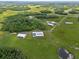 Spacious aerial view of the estate featuring multiple outbuildings, ponds and open pastures at 11657 Moore Rd, Lakeland, FL 33809