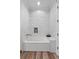 Bathroom featuring tile walls surrounding the bathtub and hardwood floors at 11657 Moore Rd, Lakeland, FL 33809