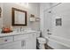 Bright bathroom with white cabinets, tub with subway tile, and framed mirror at 11657 Moore Rd, Lakeland, FL 33809