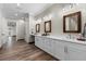 Long bathroom vanity with double sinks, wood framed mirrors, and hardwood flooring at 11657 Moore Rd, Lakeland, FL 33809