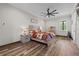 Bedroom with wood-look flooring features a ceiling fan and window for ample natural light at 11657 Moore Rd, Lakeland, FL 33809