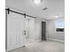 Bright bedroom featuring a barn door to the closet and a window with outdoor views at 11657 Moore Rd, Lakeland, FL 33809