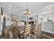 Open-concept dining area with wood flooring, a chandelier, and a large dining table at 11657 Moore Rd, Lakeland, FL 33809