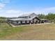 Beautiful farmhouse with a long covered porch sits on a spacious grassy lot at 11657 Moore Rd, Lakeland, FL 33809