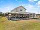 Two-story home with a metal roof, inviting front porch, and expansive lawn at 11657 Moore Rd, Lakeland, FL 33809