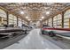 Spacious garage featuring high ceilings with exposed beams and multiple bass boats and space for vehicle storage at 11657 Moore Rd, Lakeland, FL 33809