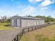 Large detached garage with multiple bay doors and a paved driveway at 11657 Moore Rd, Lakeland, FL 33809
