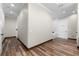 Hallway with hardwood floors leading to the bathroom featuring wood trim and natural light at 11657 Moore Rd, Lakeland, FL 33809