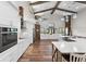 Bright, open kitchen boasts white cabinetry, stainless appliances, an island, and exposed beams for a rustic yet modern feel at 11657 Moore Rd, Lakeland, FL 33809