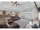 Spacious living room featuring a leather sofa, ceiling fan, and view to the pool area at 11657 Moore Rd, Lakeland, FL 33809