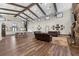 Spacious living area with a stone fireplace, exposed beams, wood floors, and stylish decor offers a welcoming atmosphere at 11657 Moore Rd, Lakeland, FL 33809