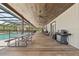 A shot of the covered patio featuring a picnic table, a grill and a view of the pool at 11657 Moore Rd, Lakeland, FL 33809