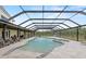 A view of the pool and spa surrounded by a screened in enclosure and overlooking a fenced in yard at 11657 Moore Rd, Lakeland, FL 33809