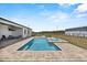 Aerial view of the backyard pool and spa featuring stone pavers and outdoor seating at 11657 Moore Rd, Lakeland, FL 33809