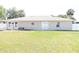 View of backyard with lush green grass, neutral home exterior, and a white fence at 2521 Tamarind Dr, Edgewater, FL 32141
