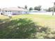 Spacious green backyard with large propane tank, white vinyl fence, and patio seating at 2521 Tamarind Dr, Edgewater, FL 32141