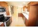 Open kitchen with wood cabinets, granite counters, stainless steel appliances, and tile flooring at 2521 Tamarind Dr, Edgewater, FL 32141