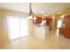 Bright kitchen and dining area with tile flooring, featuring wood cabinetry, countertop, and access to the backyard at 2521 Tamarind Dr, Edgewater, FL 32141