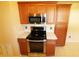 Well-lit kitchen features wooden cabinetry, stainless steel appliances, and granite countertops at 2521 Tamarind Dr, Edgewater, FL 32141
