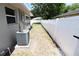 Clean side yard featuring gravel, well-maintained A/C unit and a white vinyl fence at 2521 Tamarind Dr, Edgewater, FL 32141