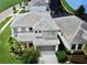Aerial view of a gray roofed two-story home in a manicured community near a lake at 4500 Monado Dr, Kissimmee, FL 34746