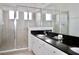 Modern bathroom featuring a glass-enclosed shower, granite countertop, and double sinks at 4500 Monado Dr, Kissimmee, FL 34746