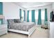 Bright bedroom with a queen bed, featuring white furniture and turquoise curtains at 4500 Monado Dr, Kissimmee, FL 34746