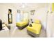 Bright bedroom with twin beds and a gray chair, featuring a ceiling fan at 4500 Monado Dr, Kissimmee, FL 34746
