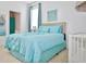 Bright bedroom featuring a queen bed with light blue bedding, a window, and decor at 4500 Monado Dr, Kissimmee, FL 34746