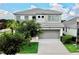 Beautiful two-story home with a gray tiled roof, concrete driveway, and well-manicured landscaping at 4500 Monado Dr, Kissimmee, FL 34746