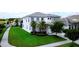 Well-maintained front yard with lush green grass, palm trees, and charming exterior of the two-story home at 4500 Monado Dr, Kissimmee, FL 34746