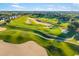 Stunning aerial view of a lush golf course with sand traps and undulating greens at 1514 Corolla Ct, Reunion, FL 34747