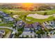 Gorgeous aerial view of the neighborhood, golf course, and sunset in the background at 1514 Corolla Ct, Reunion, FL 34747