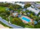 Beautiful aerial view showcasing the community pool, palm trees, and lush landscaping at 1514 Corolla Ct, Reunion, FL 34747