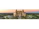 Stunning aerial view of a grand resort amidst lush greenery, golf course, and a picturesque sunset backdrop at 1514 Corolla Ct, Reunion, FL 34747