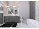 Contemporary bathroom featuring a gray vanity, soaking tub, separate glass shower, and modern fixtures at 1514 Corolla Ct, Reunion, FL 34747