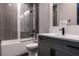 Modern bathroom with a shower over the tub, and a gray vanity with a marble countertop at 1514 Corolla Ct, Reunion, FL 34747