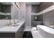 Modern bathroom with double vanity, soaking tub, and walk-in shower with gold fixtures at 1514 Corolla Ct, Reunion, FL 34747