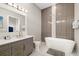 Stylish bathroom with a modern vanity, soaking tub, and sleek gray and white tile accents at 1514 Corolla Ct, Reunion, FL 34747