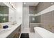 Elegant bathroom with a soaking tub, glass-enclosed shower, double vanity, and gold hardware at 1514 Corolla Ct, Reunion, FL 34747
