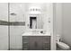 Stylish bathroom featuring a modern vanity, elegant mirror, and glass-enclosed shower with decorative tile accents at 1514 Corolla Ct, Reunion, FL 34747
