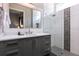 Modern bathroom featuring gray vanity with double sinks, and a glass-enclosed shower with mosaic tiles at 1514 Corolla Ct, Reunion, FL 34747