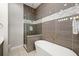 Luxurious bathroom featuring a freestanding tub, glass shower, and elegant gold fixtures at 1514 Corolla Ct, Reunion, FL 34747