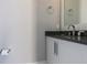 Modern bathroom featuring a sleek vanity with a dark countertop, white cabinets, and contemporary fixtures at 1514 Corolla Ct, Reunion, FL 34747