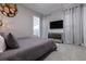 Stylish bedroom with mirrored drawers, and a large wall-mounted TV and decorated drapes at 1514 Corolla Ct, Reunion, FL 34747